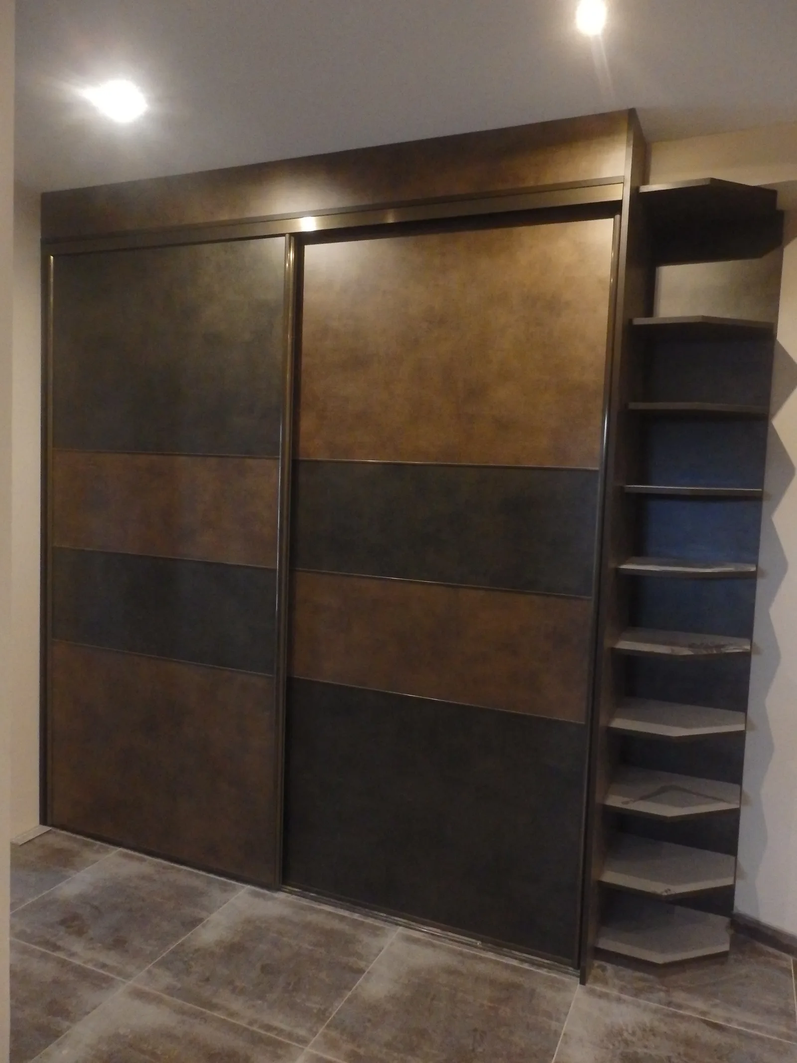 Dressing à portes coulissantes effet métal bronze, prolongé par des étagères d'angle