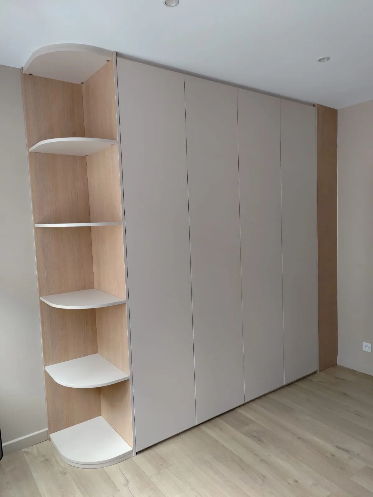 Volume de rangement taupe sans poignée, terminé par une colonne d'étagères arrondies